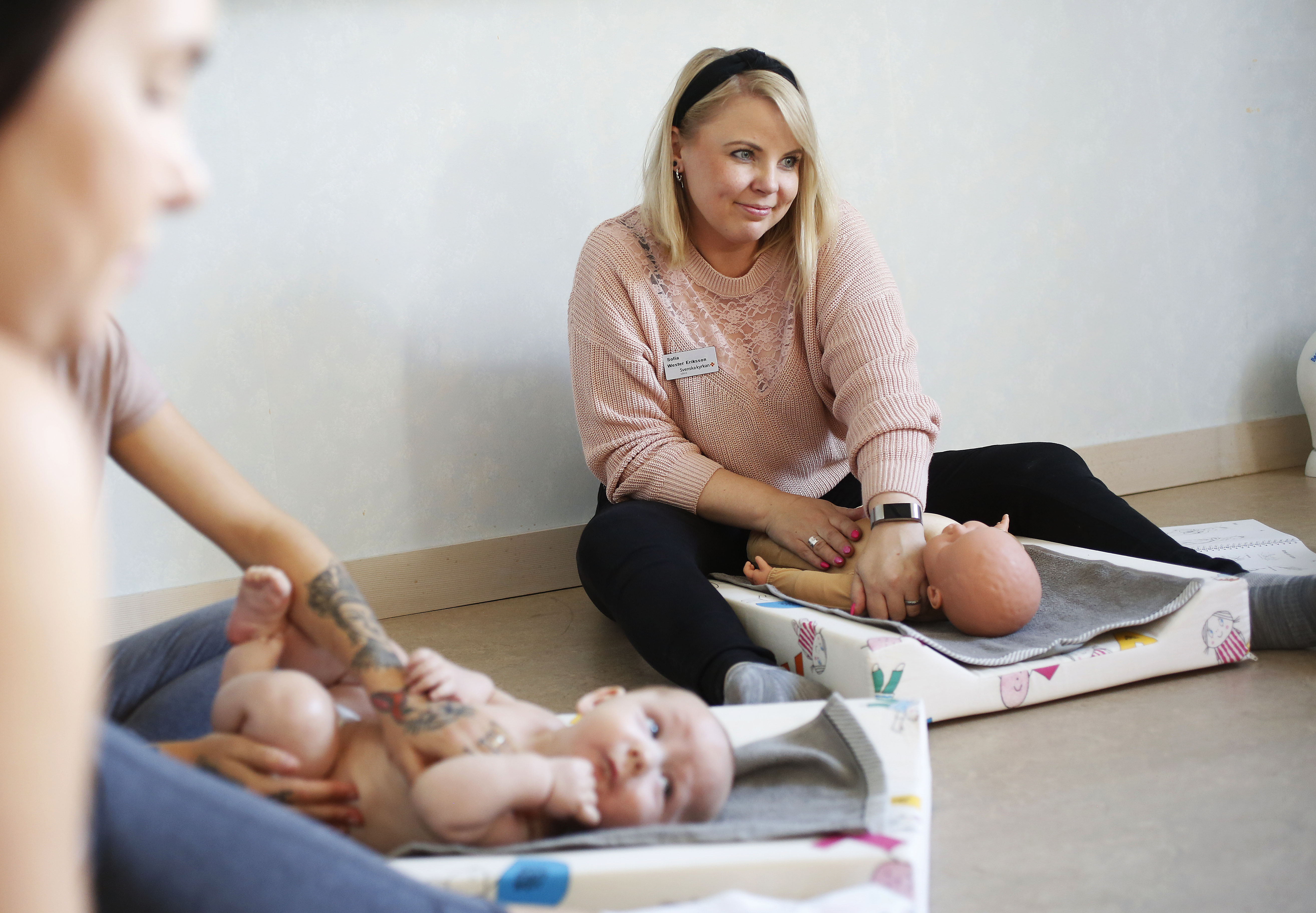 Sofia Wester-Eriksson. Framför sig har hon en naturtrogen docka i en guldig bodysuit, klädstorlek 62.